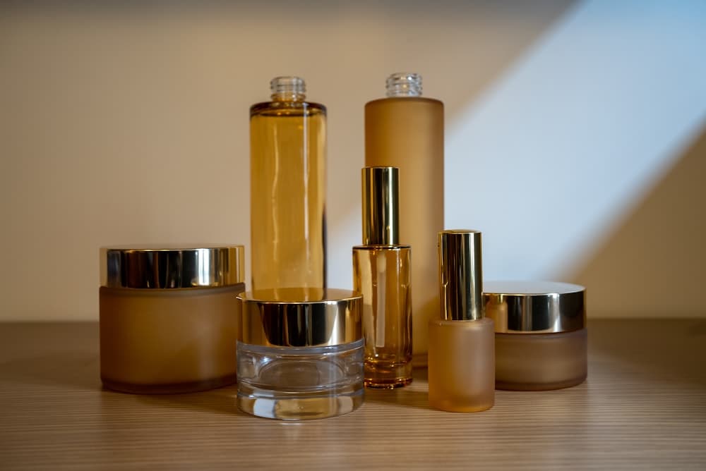 Unlabelled amber glass jars and bottles of skincare on a counter